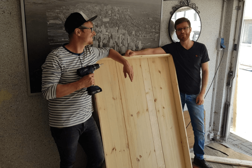 Das Saugroboter-Testareal wird von zwei Personen gehalten  